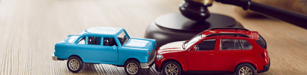 Simulated car crash involving toy cars on lawyers desk