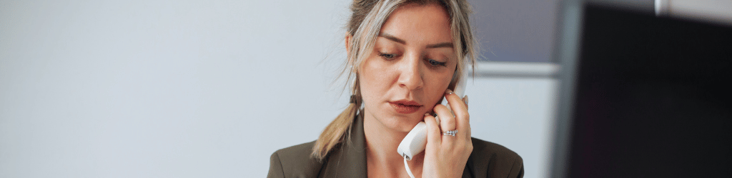 Woman making a phone call on a chorded phone